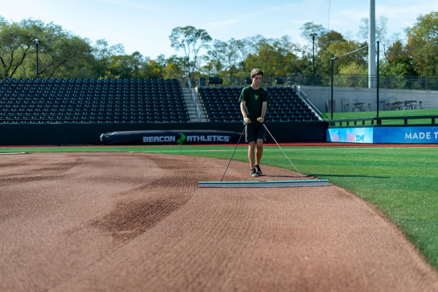 Person dragging ballfield infield soil.