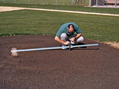 Photo: A groundskeeper measures base distance.